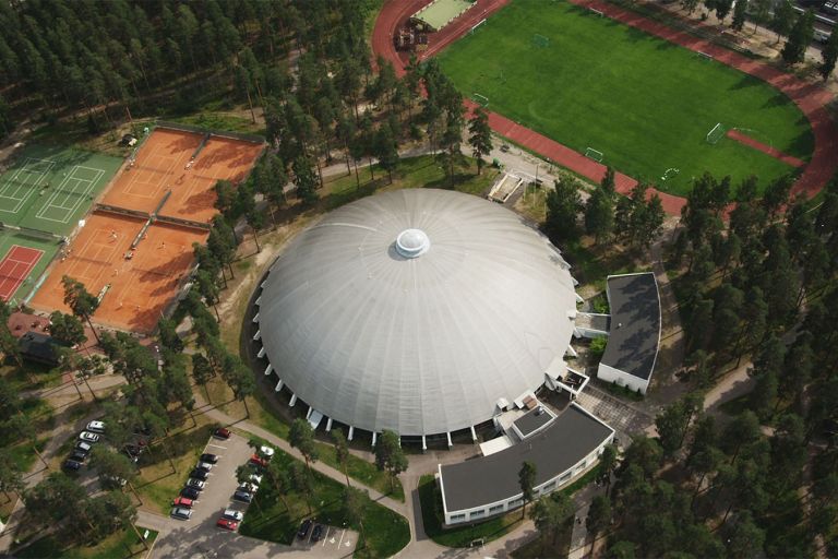 Vierumäen pyöreä kupolimainen hallin katto ilmasta kuvattuna, vieressä tenniskentät.