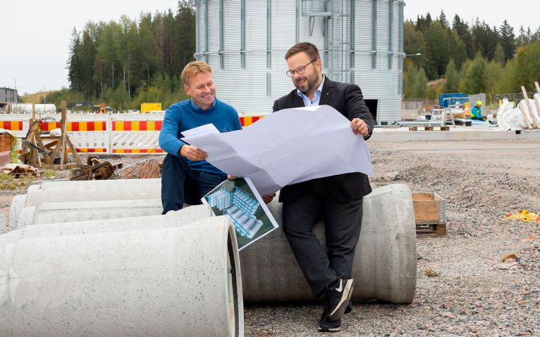 Lahden kaupun­gin­geodeetti Juha Helminen ja Viking Malt Groupin hallituksen puheen­johtaja Pär-Gustaf Relander istumassa työmaalla ja katsomassa karttaa.