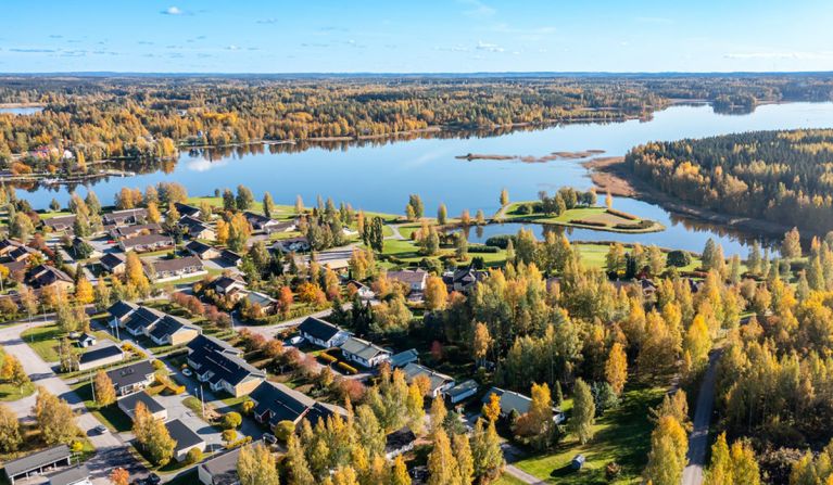 A sunny aerial view of a residential area located by the lake.