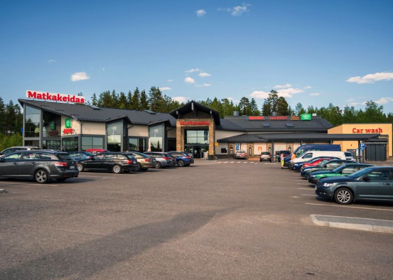 Maisema, jossa veden äärellä puiden keskeltä erottuu vanha kivinen keskiaikainen kirkko.